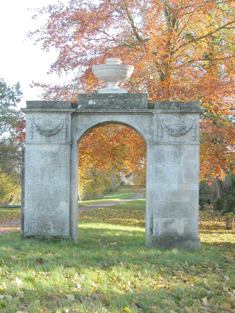 Arch decorated with swags and surmounted by elliptical Coade stone punchbowl urn 
