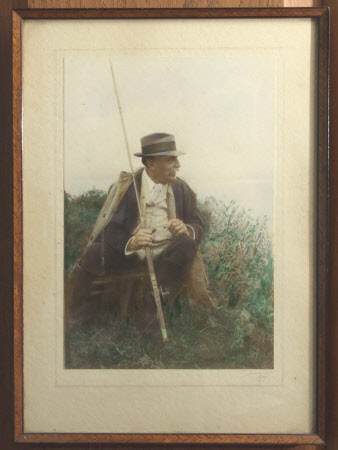 Julius Drewe, with rod and fishing cape beside a riverbank