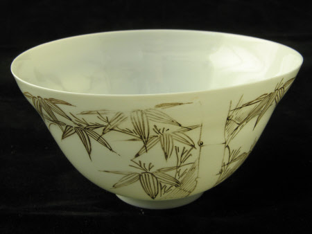 A decorated white china cup, saucer and cover.