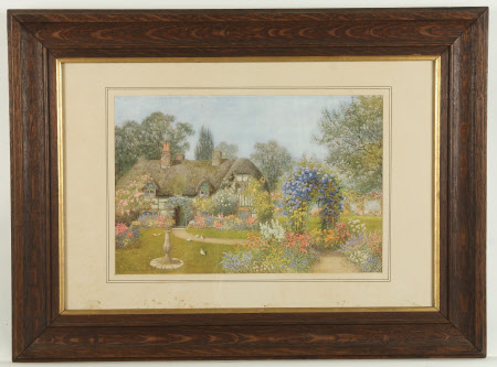 A thatched cottage in a flowery garden 