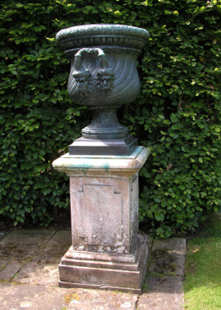 A pair of spiral-fluted urns with grimacing mascarons