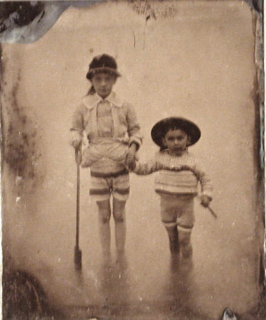 A girl and small boy paddling in the sea