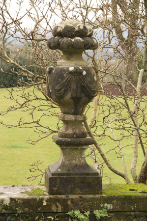 A fruit-headed urn overflowing with apples, the body of the urn adorned with swags