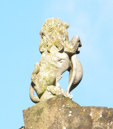 Lion holding a crested shield