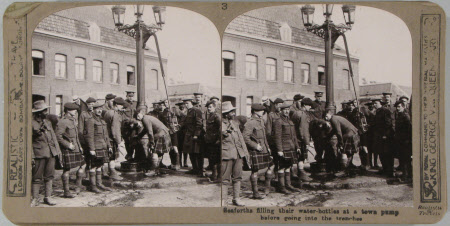 Seaforths filling their water-bottles at a town pump before going into the trenches