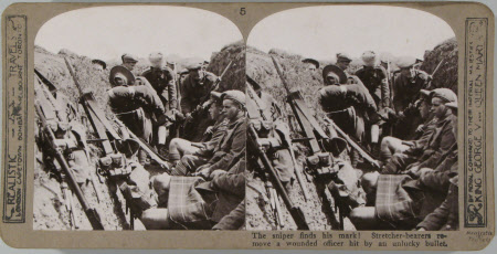 The sniper finds his mark! Stretcher-bearers remove a wounded officer hit by an unlucky bullet.