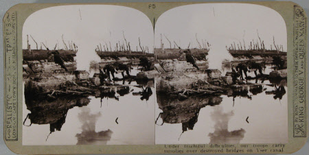 Under frightful difficulties, our troops carry supplies over destroyed bridges on Yser Canal.