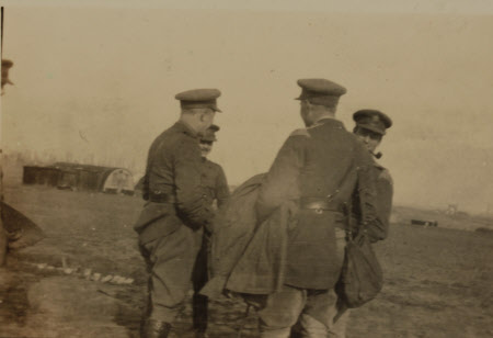 Group of four army officers standing together, on the left facing camera and smiling is the Hon. ...