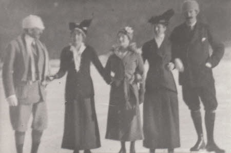 Five people linking arms and ice skating