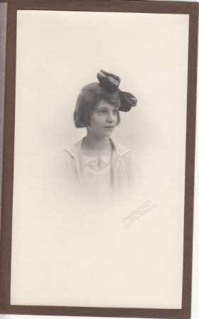 Photograph portrait of Elizabeth Hussey as a young girl, in brown paper cover