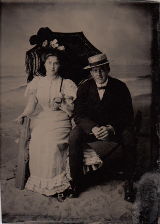 Ferrotype of Maud Kerr-Smiley and a man, possibly her brother, Ernest.  Sitting on a bench on sand.