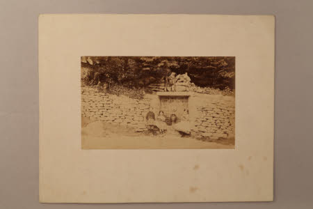 Three children by a stone wall