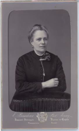 Carbon print of unknown woman with corsage and tasseled cushion.