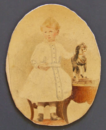 Portrait of a young boy with toy pony.
