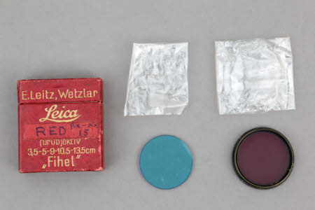A red filter in a metal mount for Leica camera together with a blue filter (no mount).