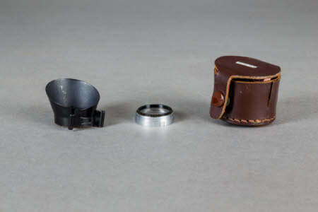 A lens hood and yellow filter in a leather case