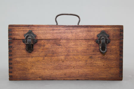 A wooden lens carrying box with six padded compartments.