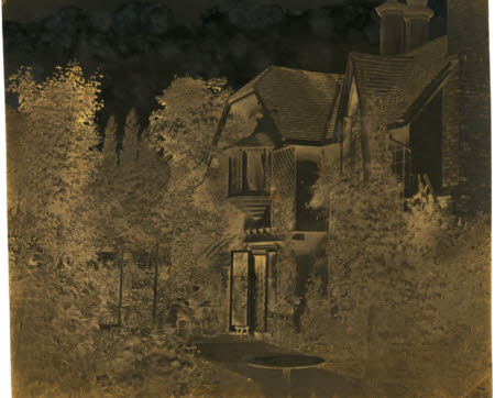 Man seated in the garden outside a house