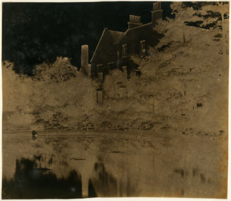 House and trees, with reflections in a lake