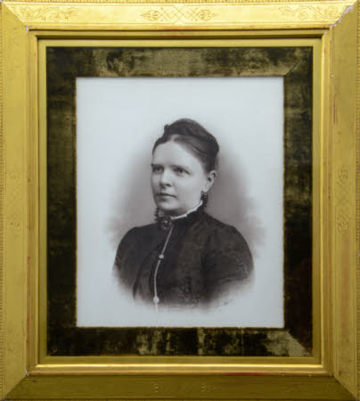Head and shoulders portrait of a lady, in a dark dress with high necked, white edged collar.