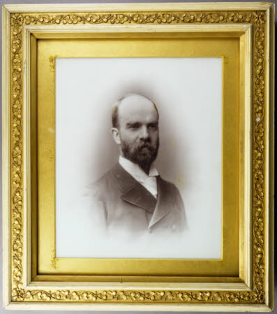 Head and shoulders portrait of a bearded man, high collar and white tie.