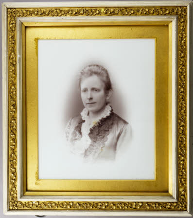 Head and shoulders portrait of a woman in a dress with an ornate neckline.